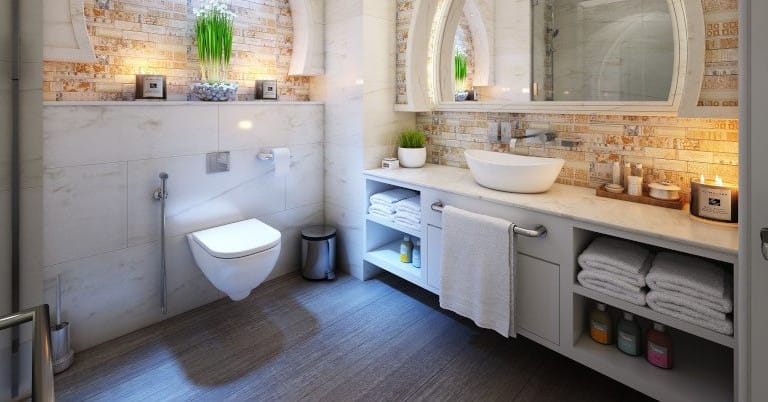 A bathroom with toilet, sink, counter, and space under the counter.