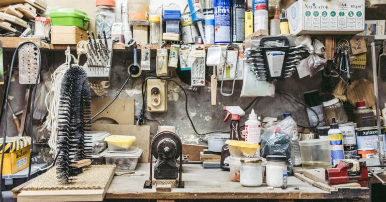 A garage work bench with tools and clutter.