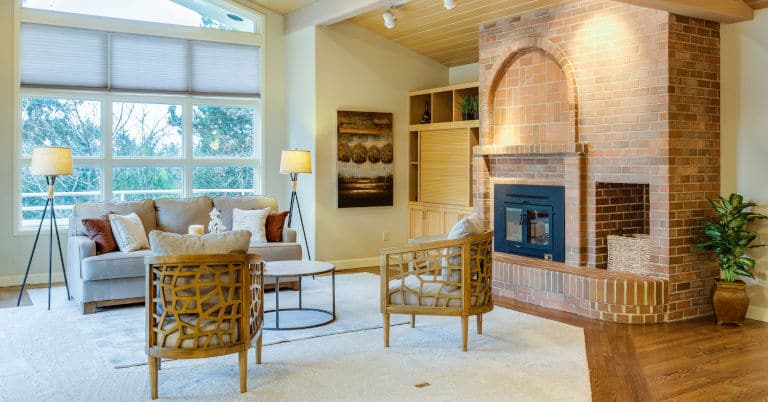 A decluttered living room with a brick fire place.