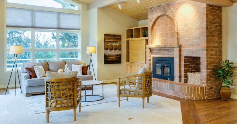 A decluttered living room with a brick fire place.
