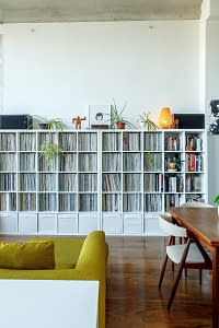 A decluttered living room with a couch, desk, and book shelves.