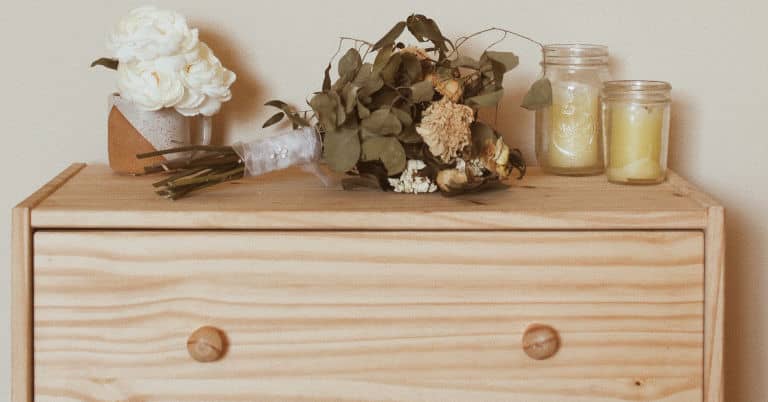 A clothes dresser drawer with flowers and candles.